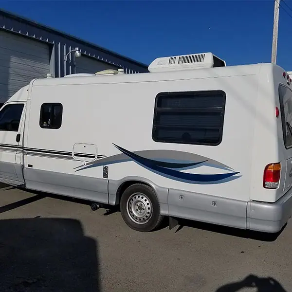 The same Class B camper van after body repair and paint, graphics restored