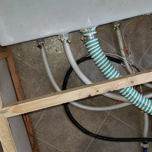 RV drain and supply lines routed under the floor