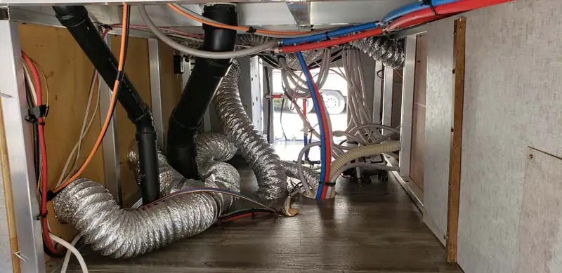 RV furnace ducting and water lines opened up for repair