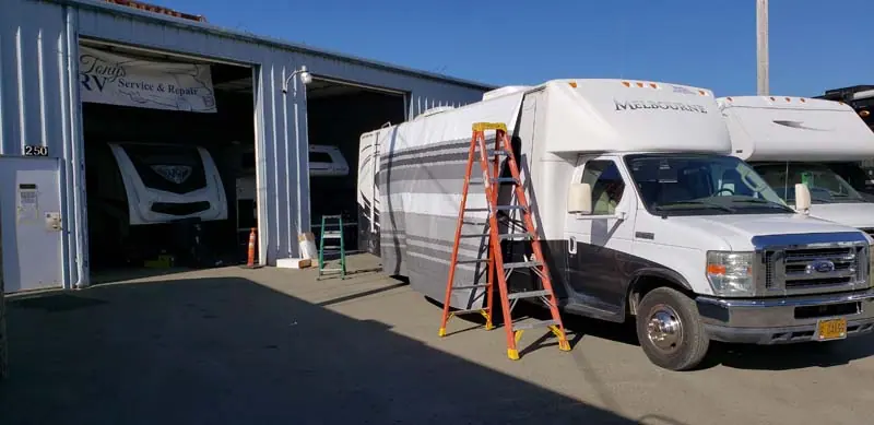 Class C motorhome in an open service bay at Tony's RV in Coos Bay